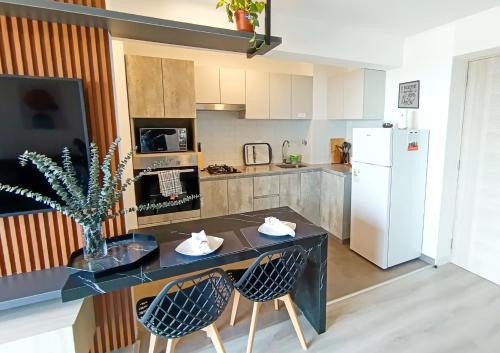 a kitchen with a table and two chairs and a refrigerator at Elegante Departamento Con Vista al Mar Full Comodidad in Lima