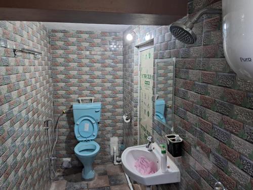 a bathroom with a blue toilet and a sink at Room in Kalimpong in Kalimpong