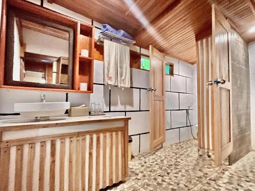 a bathroom with a sink and a mirror at Bunaken Guesthouse The Queen's in Bunaken