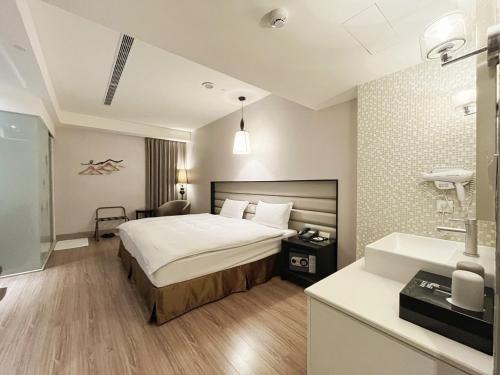 a hotel room with a bed and a sink at Stay Hotel - Taichung Yizhong in Taichung
