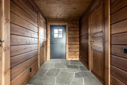 a hallway with wooden walls and a blue door at Egen bastu, nybyggd stuga, 4 sovrum, utsikt över horisont in Idre
