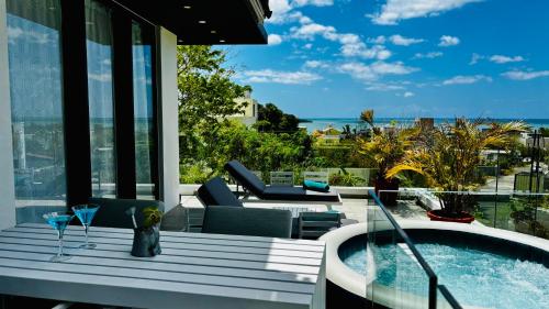 a balcony with a tub and a view of the ocean at Sublima Villa, Luxe et élégance in La Gaulette