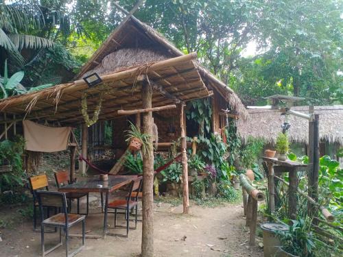 a hut with a table and chairs in front of it at ecolodge khamu homestay guesthouse in Ban Pang Hat