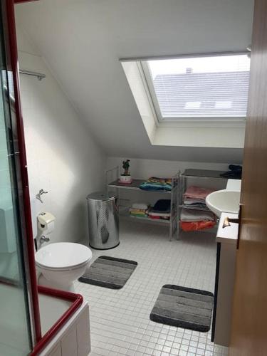 a attic bathroom with a toilet and two sinks at Stilvolles Studio in Vallendar