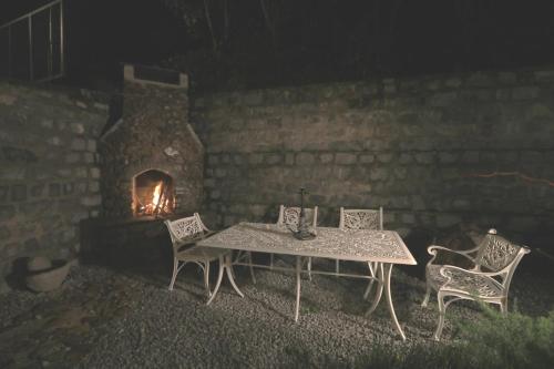 a table and chairs in front of a brick fireplace at Halli Hithalu Homestay in Chikmagalūr