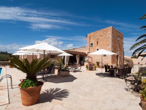a patio with tables and umbrellas and a building at Agroturismo S Hort de Can Carrio AG226 in Ses Salines