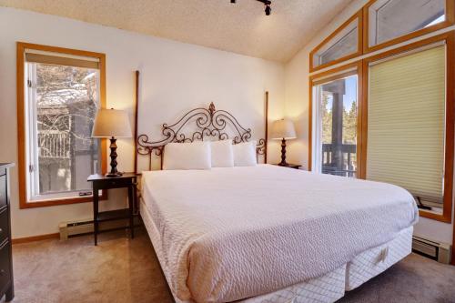 a bedroom with a large bed and two windows at Cc301 Cross Creek Condo in Frisco