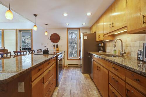 a large kitchen with wooden cabinets and a refrigerator at Cc301 Cross Creek Condo in Frisco