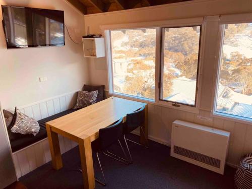 斯瑞德伯Banjo 3 Chalet - Magnificent view and great location的一间有木桌和两扇窗户的小房间