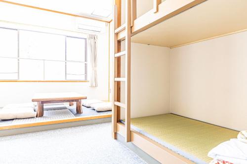 a room with bunk beds and a table at Guesthouse Sunaen - Vacation STAY 49064v in Tottori