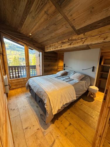 une chambre avec un lit dans une pièce aux murs en bois dans l'établissement Duplex aux pieds des pistes à Rochebrune, à Megève