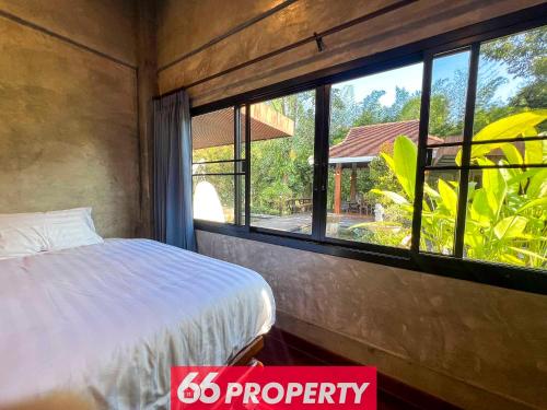 a bedroom with a bed and a large window at Nature Getaway in Classic Thai Home - Quiet Local Life in Chiang Mai