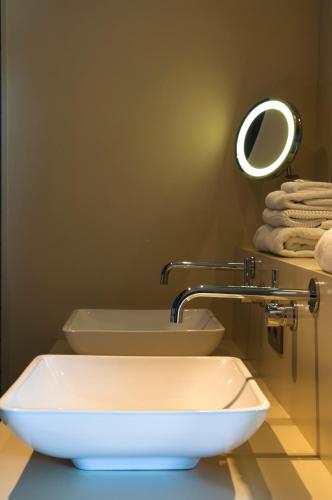 a bathroom with two sinks and a mirror and towels at Guesthouse Recour in Poperinge