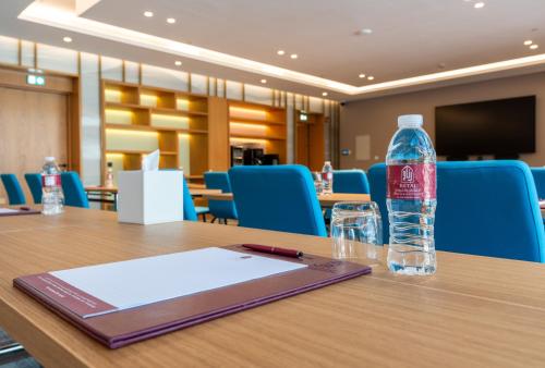a bottle of water sitting on top of a table at West Walk Retaj Hotel in Doha
