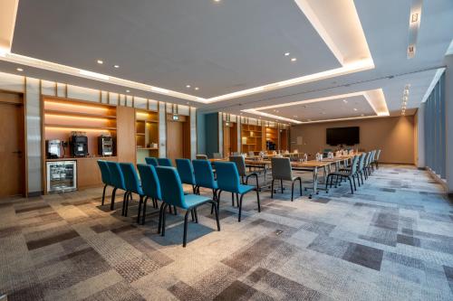 a dining room with a long table and chairs at West Walk Retaj Hotel in Doha