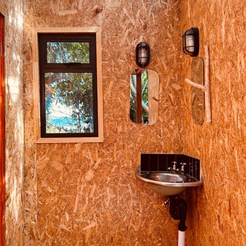a bathroom with a sink and two mirrors at The Urban Cabin in Knysna