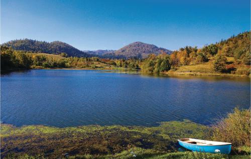 a blue boat sitting on the shore of a lake at Lovely Home In Tuk Vojni in Tuk Vojni