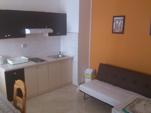 een keuken met een wastafel en een bank in een kamer bij Brig Apartments in Živogošće