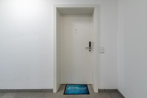 a book sitting on the floor in front of a door at Well-Home Apartments Velden in Velden am Wörthersee