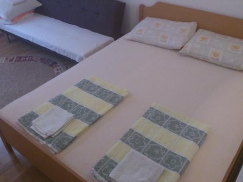 twee bedden in een kamer met handdoeken erop bij Brig Apartments in Živogošće