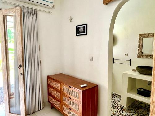 a room with a wooden dresser and a mirror at Pura Vida in Uluwatu