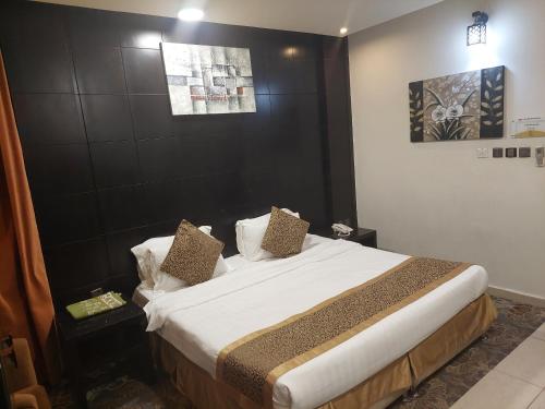 a bedroom with a large bed with white sheets and pillows at زيفل للشقق المخدومة in Buraydah