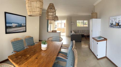 a dining room with a wooden table and chairs at Secrets 1 at Waterkant 7 in Jeffreys Bay