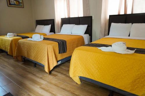 a room with three beds with towels on them at Posada Rabin Ajaw in San Juan La Laguna