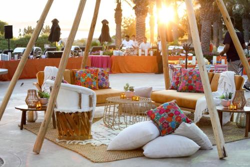 a group of chairs and tables with pillows on them at Casa Maat at JW Marriott Los Cabos Beach Resort & Spa in San José del Cabo