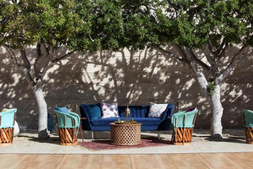 a group of chairs and a blue couch and trees at Casa Maat at JW Marriott Los Cabos Beach Resort & Spa in San José del Cabo