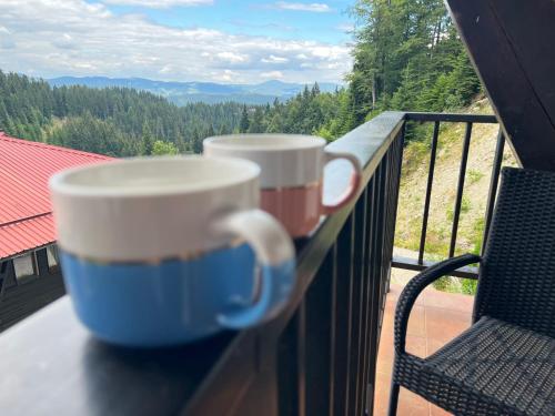 two coffee cups sitting on a table on a balcony at Mountain View, Grand Monastery Pamporovo, top location in Pamporovo