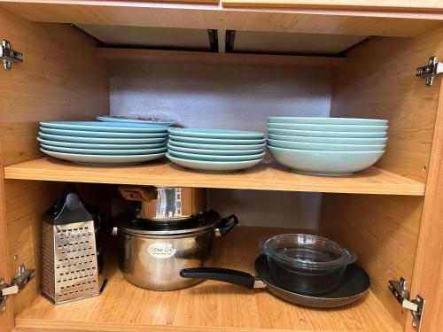 a shelf with plates and bowls in a cabinet at Mountain View, Grand Monastery Pamporovo, top location in Pamporovo