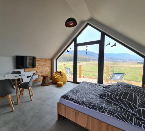a bedroom with a bed and a large window at Wataha pod Basztami - Beta - Domki całoroczne in Wünschelburg