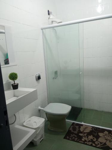 a bathroom with a shower and a toilet and a sink at Kasa Hostel Karaokê in Balneário Camboriú