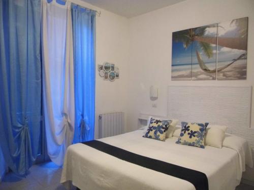 een slaapkamer met een bed met blauwe gordijnen bij Hotel Birillo in La Spezia