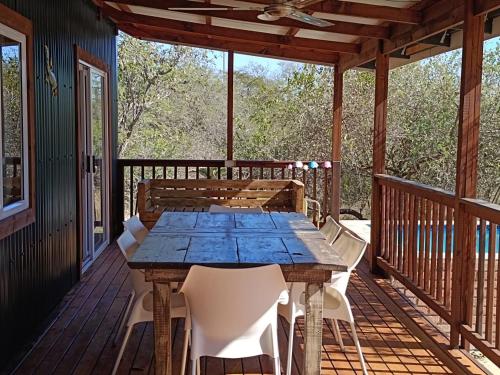 a wooden table and chairs on a deck at Sunset on Kingfisher in Marloth Park