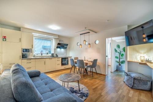 a living room and kitchen with a couch and a table at Well-Home Apartments Velden in Velden am Wörthersee