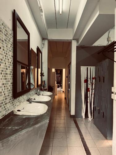 a bathroom with four sinks and a row of mirrors at Happiness Hostel in Phra Ae beach