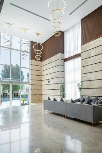a lobby with a couch in a room with windows at Elaf Qinwan Hotel in Makkah