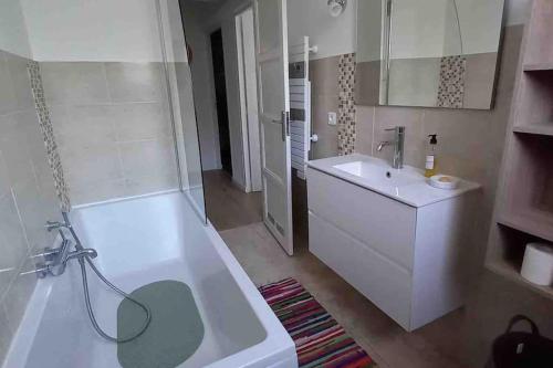 a white bathroom with a tub and a sink at Bastia nid in Bastia
