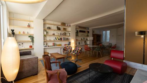 un salon avec un canapé, une table et des chaises dans l'établissement Chambres au coeur du quartier historique - Maison Alternativi, à Caen