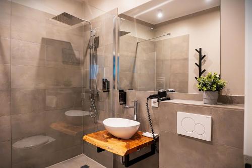 a bathroom with a sink and a glass shower at Liro Hotel Viersen in Viersen