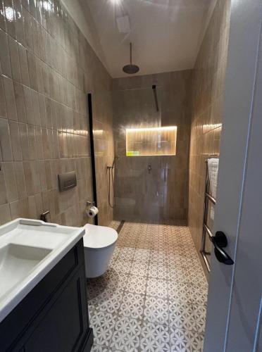 a bathroom with a shower and a toilet and a sink at The Stables at Minstrel Court in Cambridge