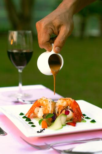 a person is pouring sauce on a plate of food at Inya Lake Hotel Yangon in Yangon