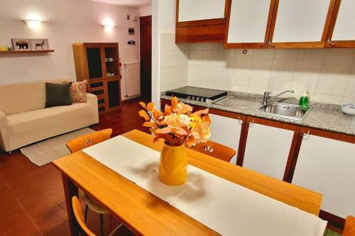 a kitchen with a table with a vase of flowers on it at trilocale panorama val di fiemme in Predazzo