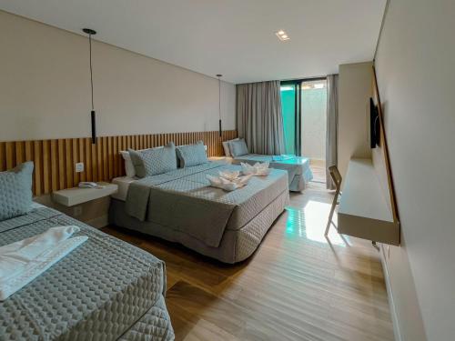 a hotel room with two beds and a television at Marino Beach Hotel in Cabo Frio