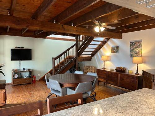 a living room with a table and chairs and a staircase at Cozy Wood Retreat in Centurion
