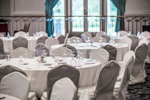 a room filled with tables and chairs with white tablecloths at Inya Lake Hotel Yangon in Yangon
