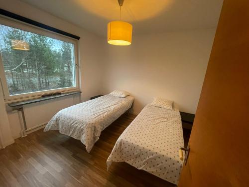 two beds in a room with a window at Apartment in Skellefteå