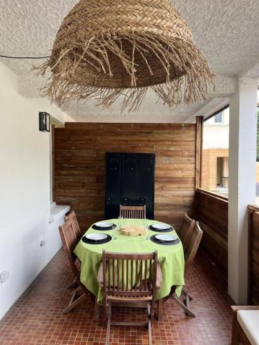 une salle à manger avec une table et des chaises vertes dans l'établissement Etxetxoa, à Argelès-Gazost